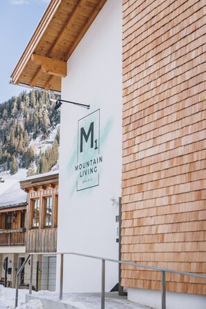 A building with a sign reading "M1 Mountain Living" and a wooden exterior.