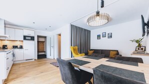 A modern kitchen with white cabinets, a wooden countertop, and a built-in microwave. - M1 - Apartment with garden 2 (Rauris)