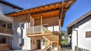 A two-story building with a wooden balcony and a staircase leading to the upper floor. - 2 bedroom gorgeous home in Lamon (Lamon)