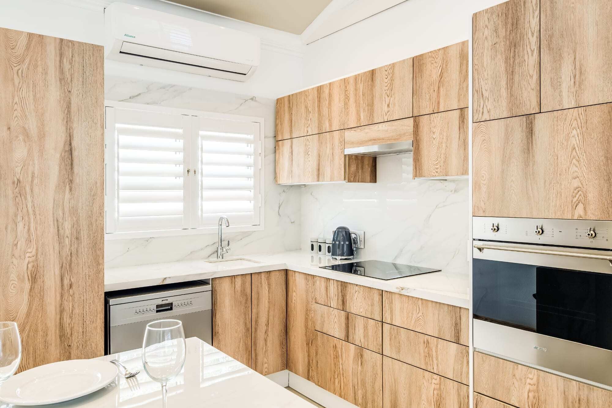 A modern kitchen with wooden cabinets, a built-in oven, and a dishwasher.