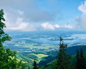 Vista panorámica de un valle con un pueblo, rodeado de bosques y cuerpos de agua.
