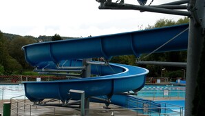 A water slide structure with a pool in the background.
