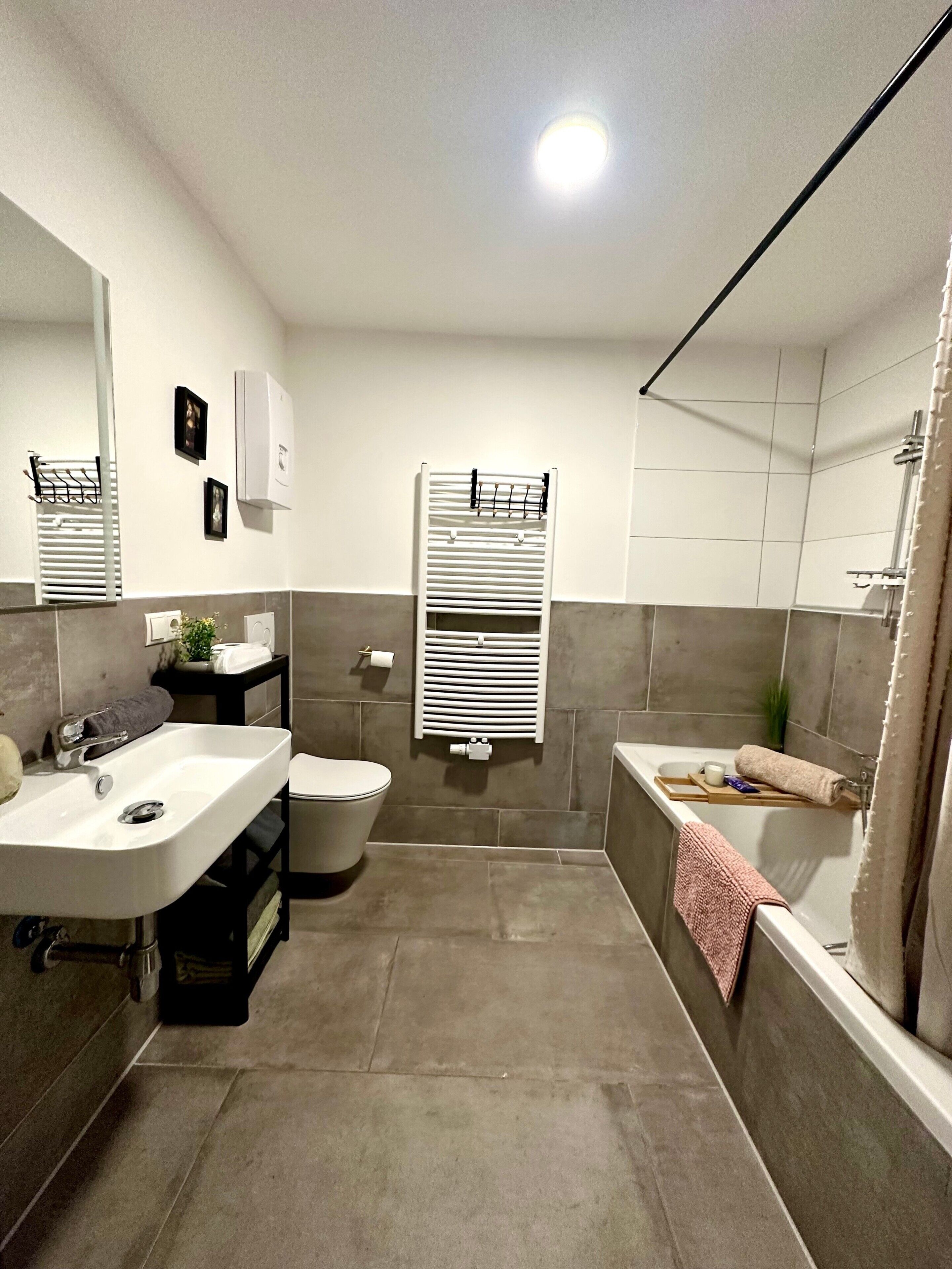 A modern bathroom with a sink, toilet, and bathtub.