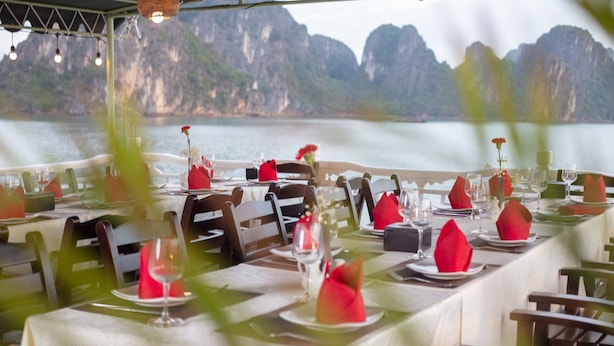 A table set for dining with a view of a mountainous landscape. - Ruby Cruise (Tuan Chau)