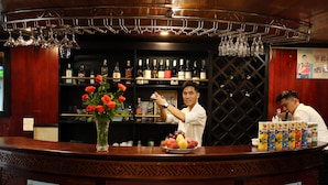 A bar area with a counter, wine bottles, and a fruit display. - Ruby Cruise (Tuan Chau)