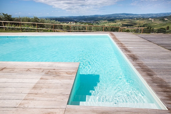 Relax by the pool surrounded by a scenic view of rolling hills.
