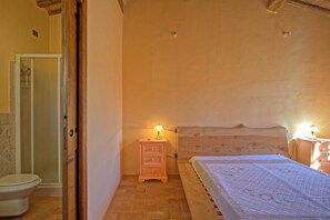 Cozy retreat with a comfortable bed, nightstand, and bathroom.