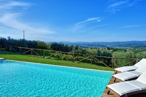 Relax by the serene pool surrounded by lush greenery and breathtaking valley views.