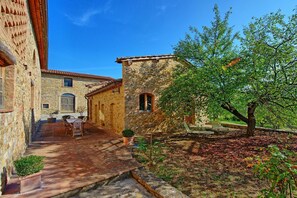 Stroll through the serene courtyard, surrounded by lush foliage and a historic stone building.