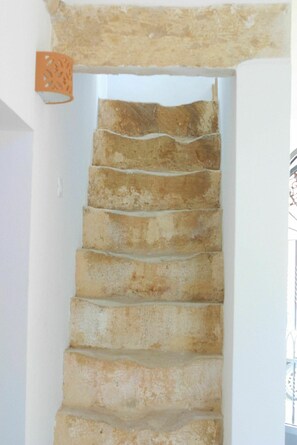 Stairs lead to an upper level with a decorative metal railing.