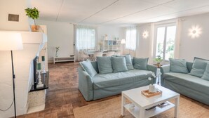 Ein modernes Wohnzimmer mit einer Sofagarnitur, einem Couchtisch und einer Lampe.