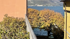Vista de varanda sobre um lago, com folhagem outonal e uma montanha ao fundo.