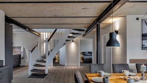 Un interior moderno con una escalera, comedor y cama.
