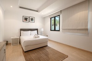 A bedroom with a bed, a nightstand, a lamp, a window with a view, and two framed pictures on the wall. - Villa on Beach w/ Private Pool The Palm Jumeirah (Dubai)