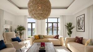 A spacious living room with a large window, a central coffee table, and a sofa with multiple cushions. - Villa on Beach w/ Private Pool The Palm Jumeirah (Dubai)