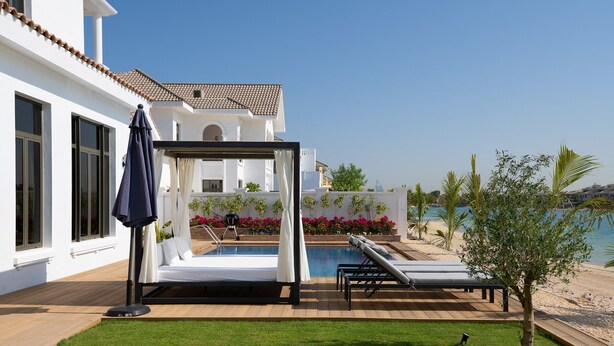 A poolside area with a bed, lounge chairs, and a pergola. - Villa on Beach w/ Private Pool The Palm Jumeirah (Dubai)