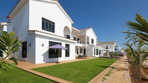 A white two-story house with a balcony, a lawn, and a pathway leading to the entrance. - Villa on Beach w/ Private Pool The Palm Jumeirah (Dubai)