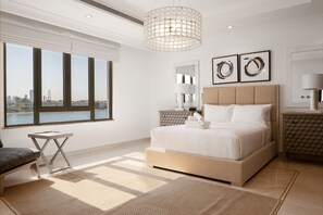 Un dormitorio moderno con una cama grande, vistas de la ciudad y un paisaje urbano visible a través de la ventana.