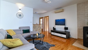 A modern living room with a sofa, coffee table, and TV. - Awesome apartment in Okrug Gornji with WiFi (Okrug Gornji)