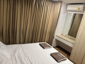 Une chambre d’hôtel avec un lit, un miroir et un appareil de climatisation.