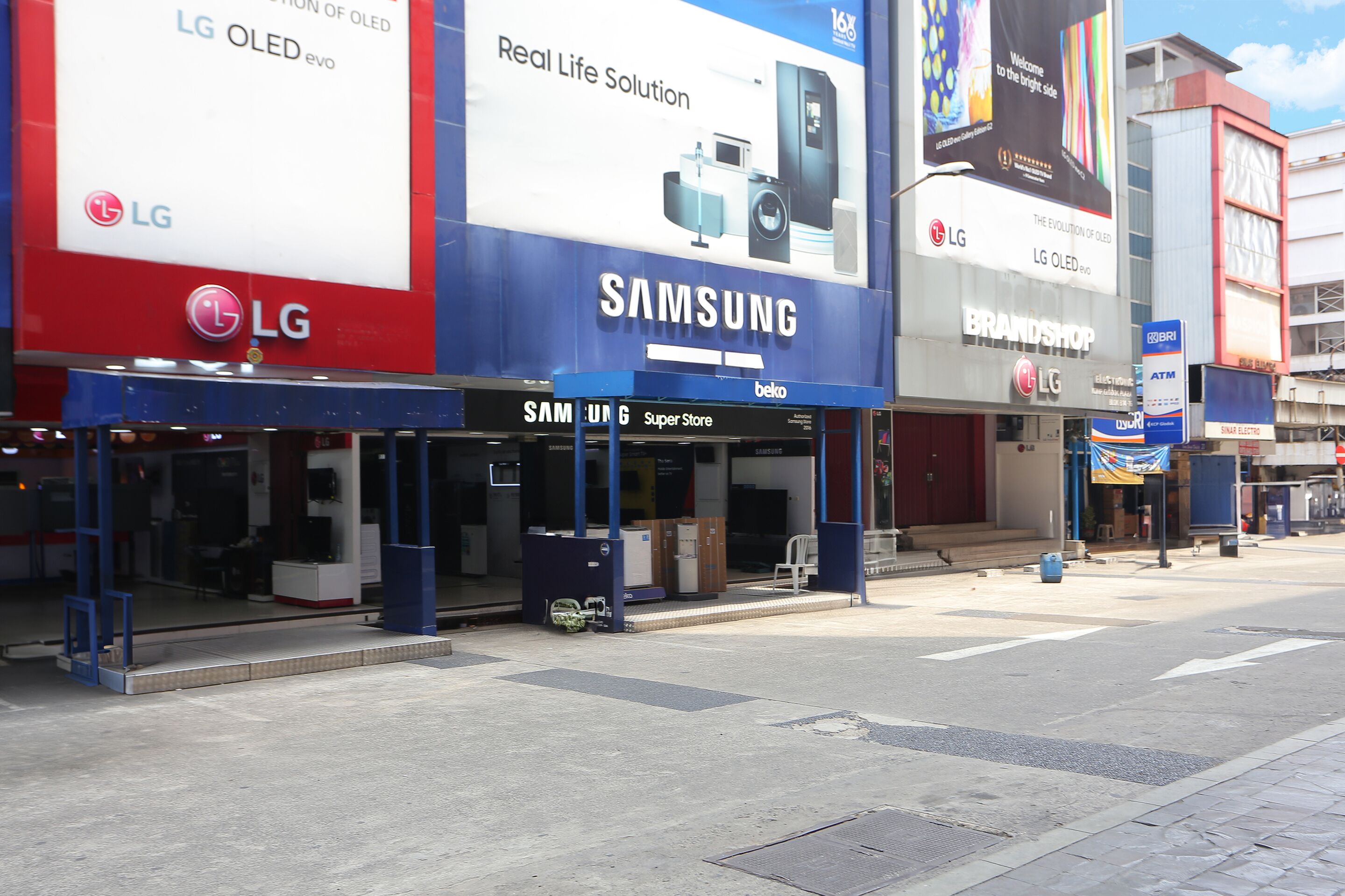 A street view with storefronts advertising LG and Samsung.
