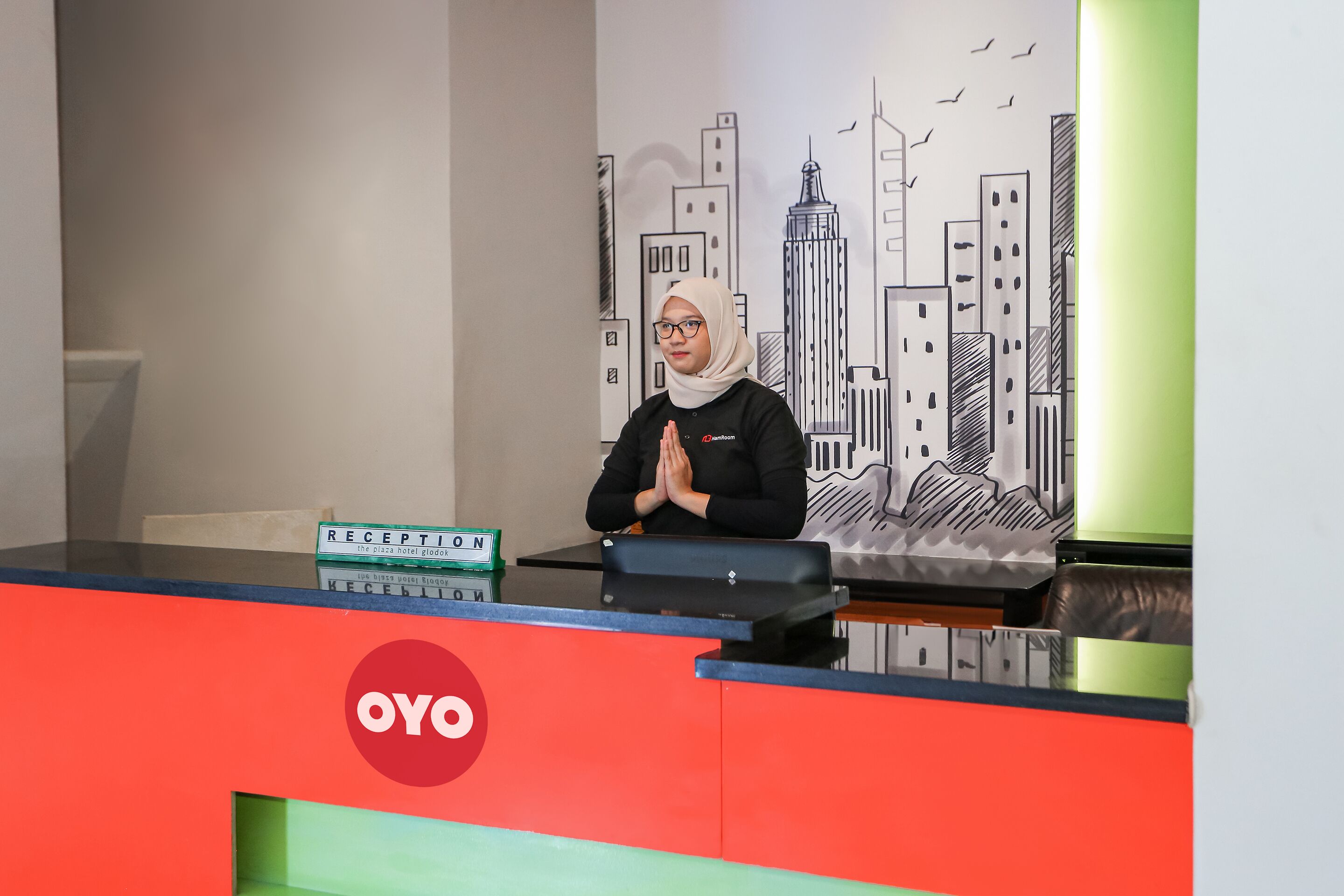 A reception desk with a cityscape mural in the background.