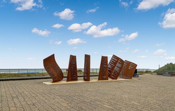 A metal sculpture with inscriptions on a paved walkway by the sea. - Gorgeous apartment in Katwijk aan Zee (Katwijk aan Zee)