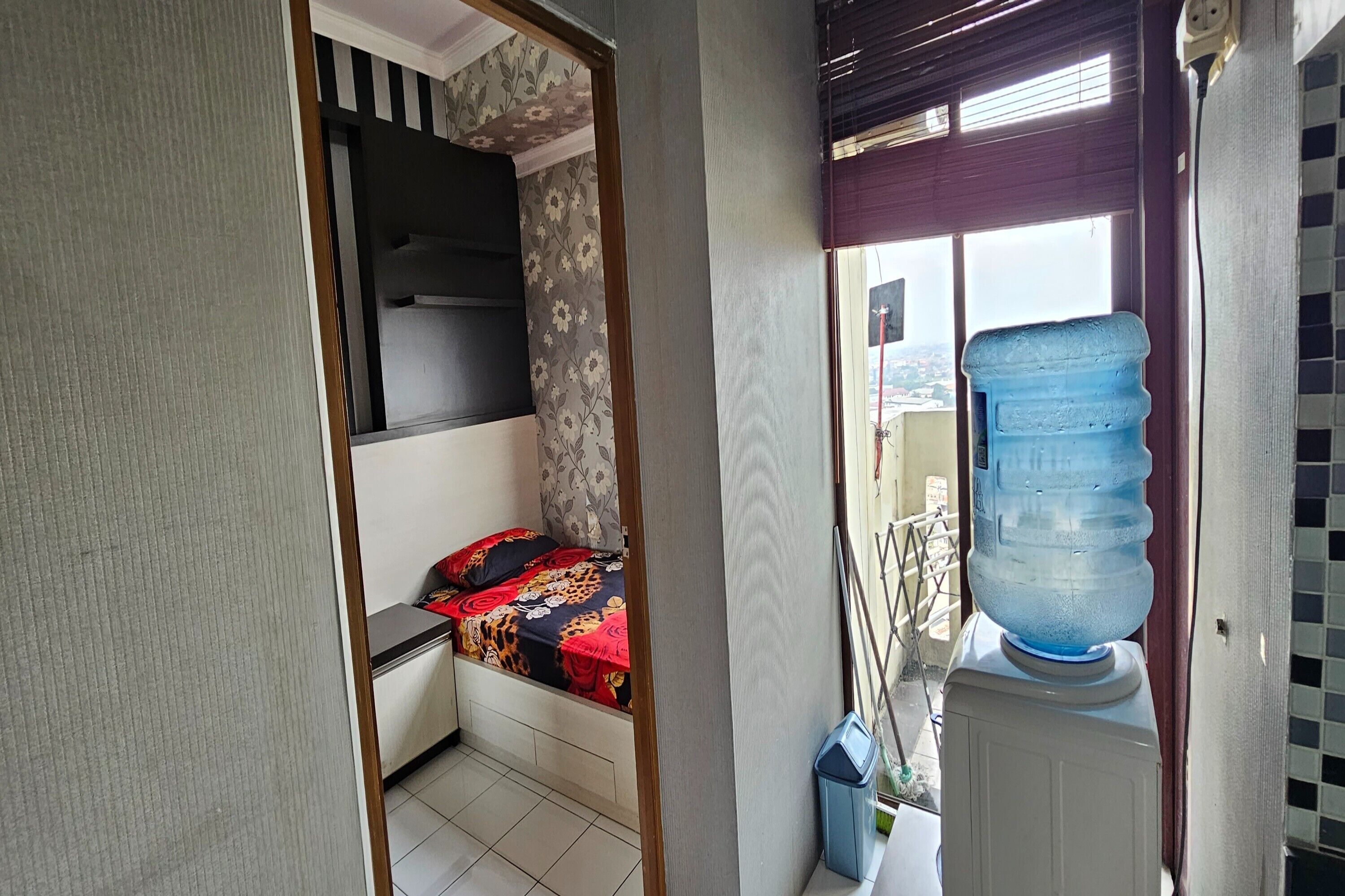 Ein Schlafzimmer mit Bett, Wasserspender und Blick ins Freie.