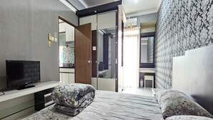Une chambre à coucher avec un lit, une télévision et une armoire.