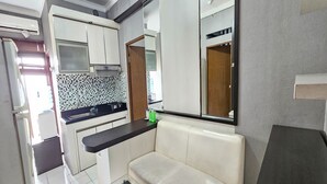 Une cuisine moderne avec des meubles blancs, un plan de travail noir et une table basse en verre.