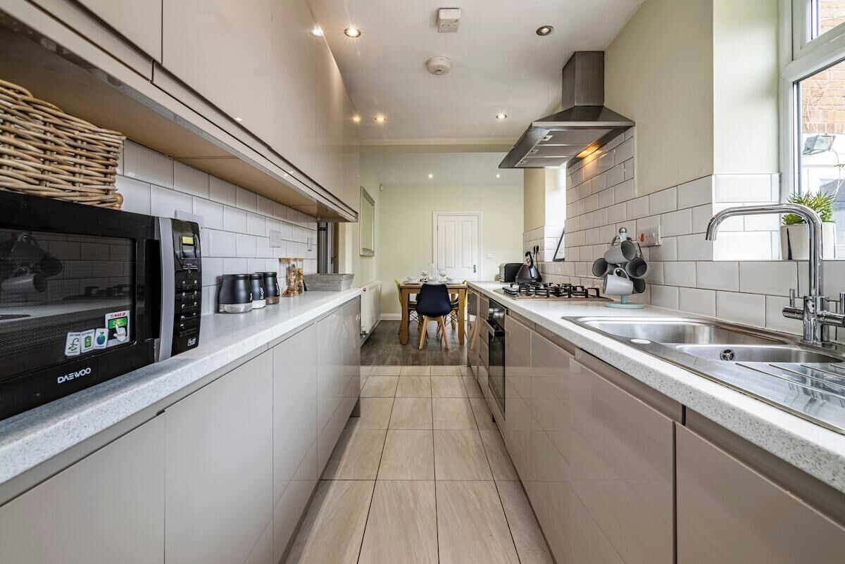 A modern kitchen with a microwave, stove, and sink.