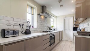 A modern kitchen with a built-in oven, a kettle, and a toaster on the counter.