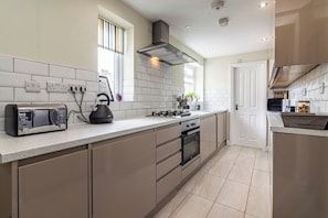 A modern kitchen with a built-in oven, a kettle, and a toaster on the counter.