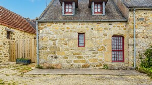 A stone building with two red-framed windows and a small door, surrounded by gravel and a wooden fence. - Penty Landromiou by Interhome (Crozon-Morgat)