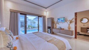 A modern hotel bedroom with a large bed, a television, a bathroom, and a view of a swimming pool.