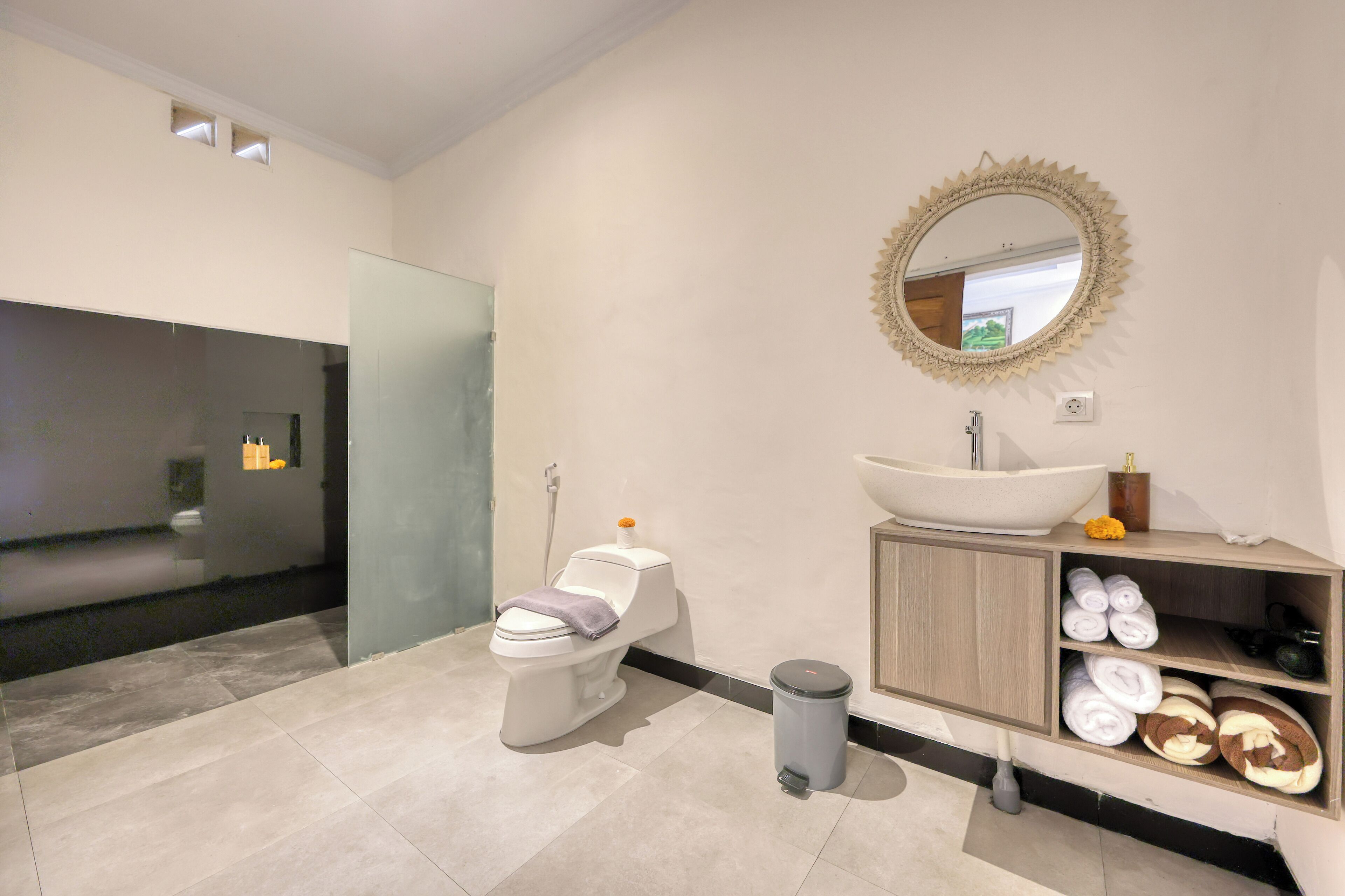 A modern bathroom with a toilet, sink, and vanity.