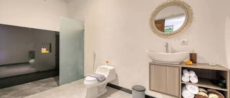 A modern bathroom with a toilet, sink, and vanity.