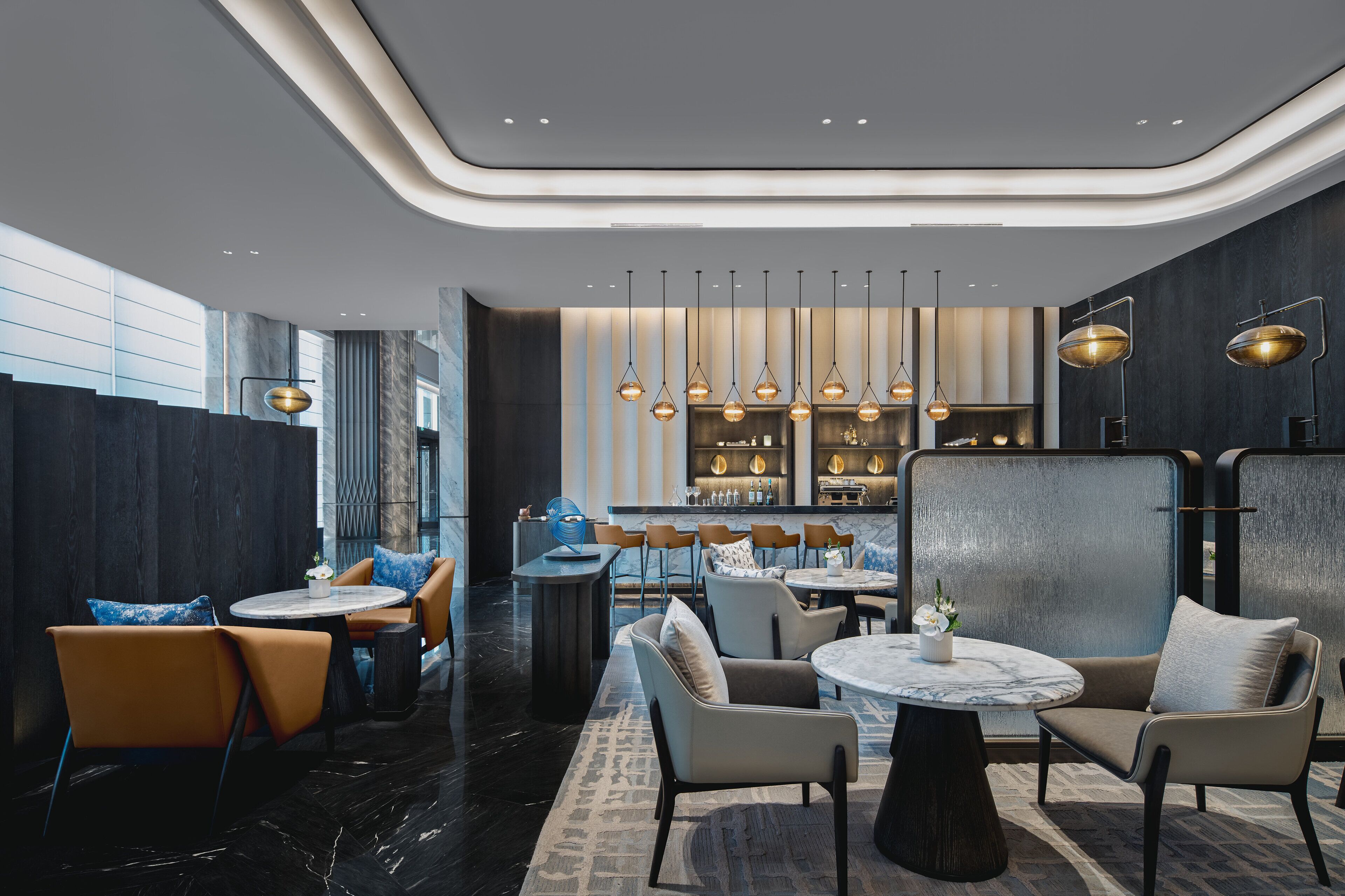 A modern interior with a bar area, seating arrangements, and a marble-patterned floor.