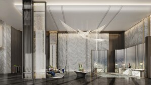 Eine moderne Lobby mit Marmorwänden, einem Empfangstresen und einem außergewöhnlichen Kronleuchter.