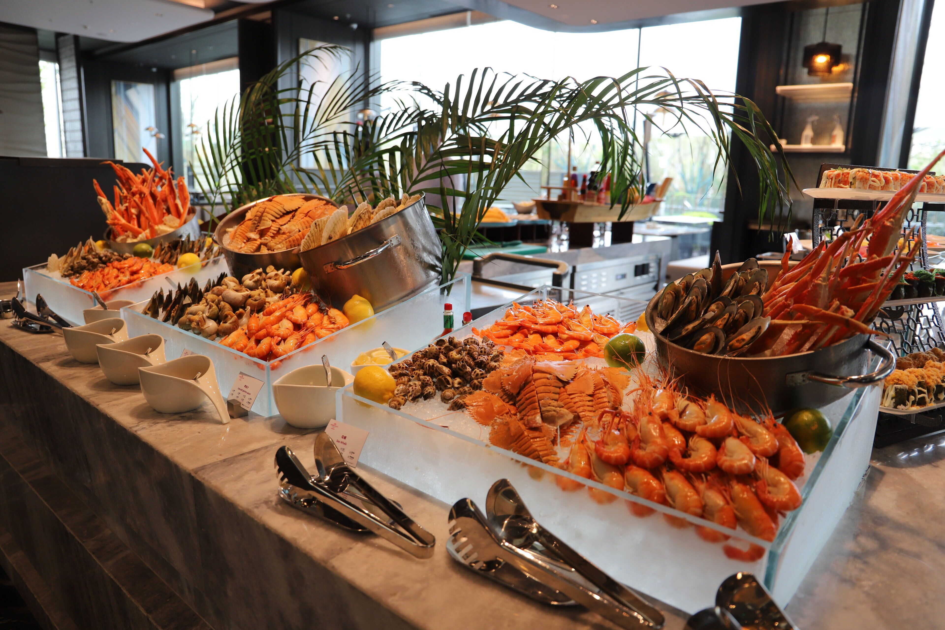 Un buffet proposant une variété de fruits de mer, notamment des crevettes, des homards et des huîtres.