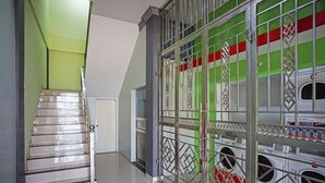 A staircase leading to a laundry area with metal gates and washing machines.