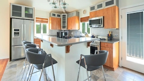 A modern kitchen with a central island, stainless steel appliances, and wooden cabinetry. - 6 BR, Pool, Hot Tub and 5 min to Ocean (Loveladies)