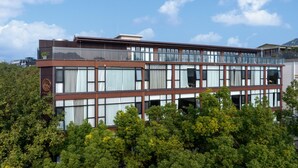 A multi-story hotel with a modern design, featuring large windows and balconies.