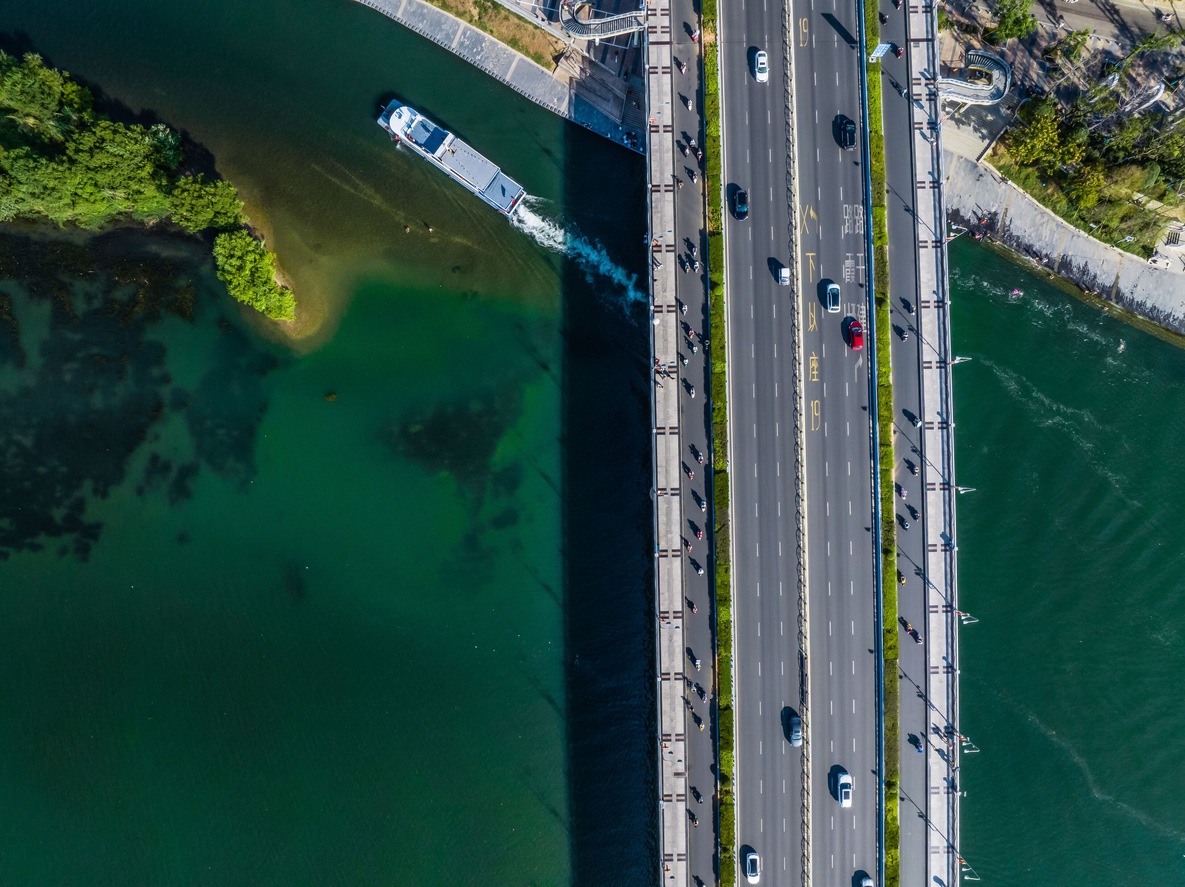 Une vue aérienne d’un pont avec une route et un bateau.