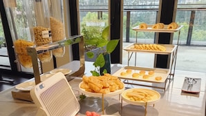 A buffet table with various food items including watermelon slices, cheese slices, and pastries.