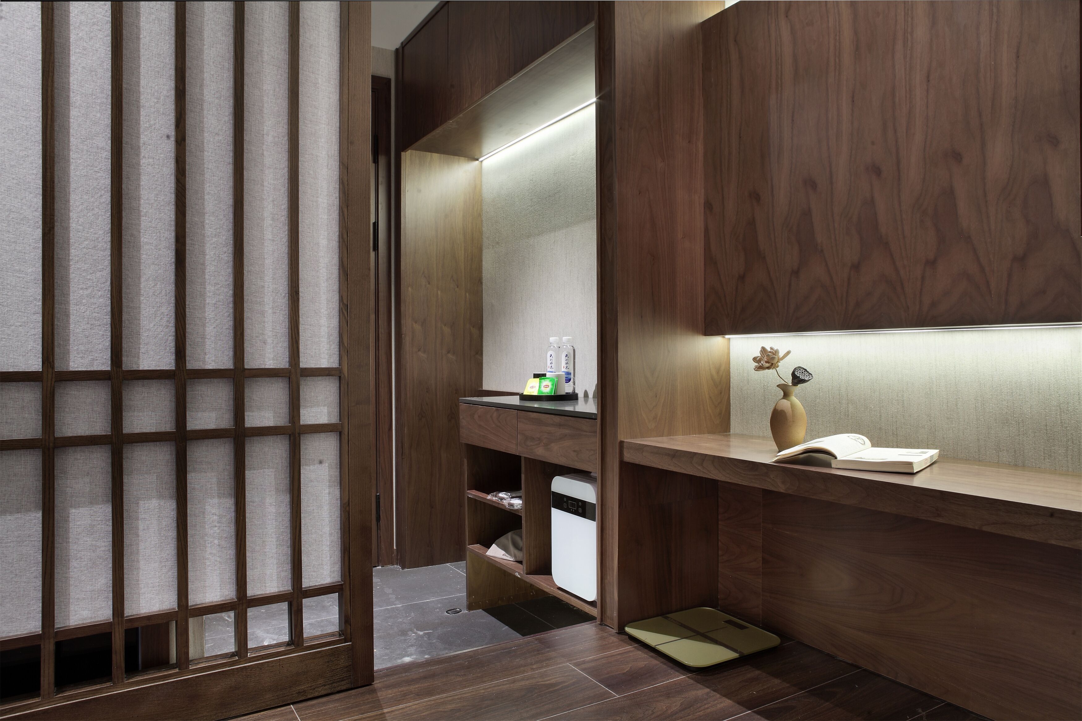 A modern bathroom with a wooden vanity, a mirror, and a small shelf with toiletries.