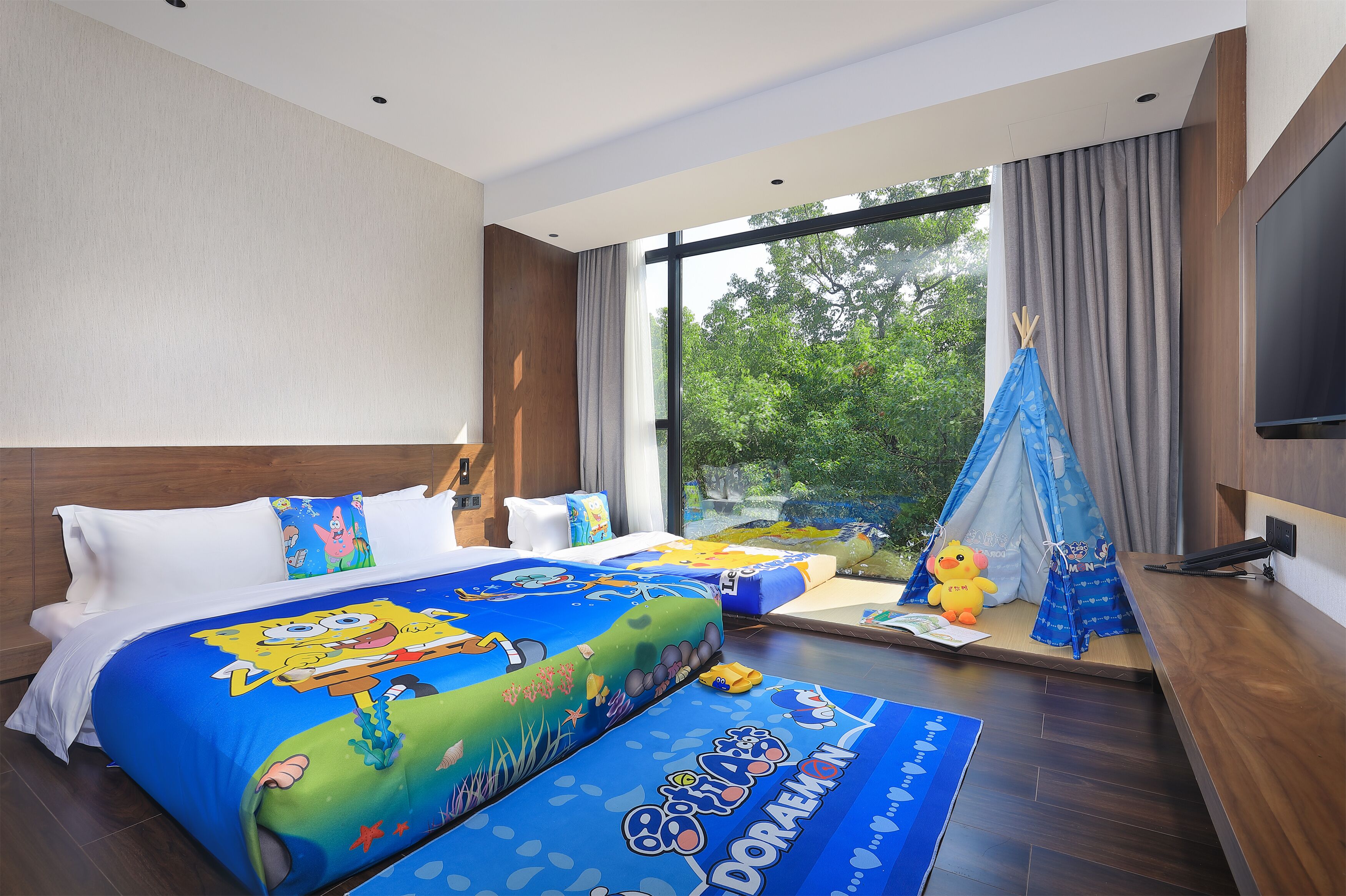 A hotel room with two beds, a large window, a TV, and a tent.
