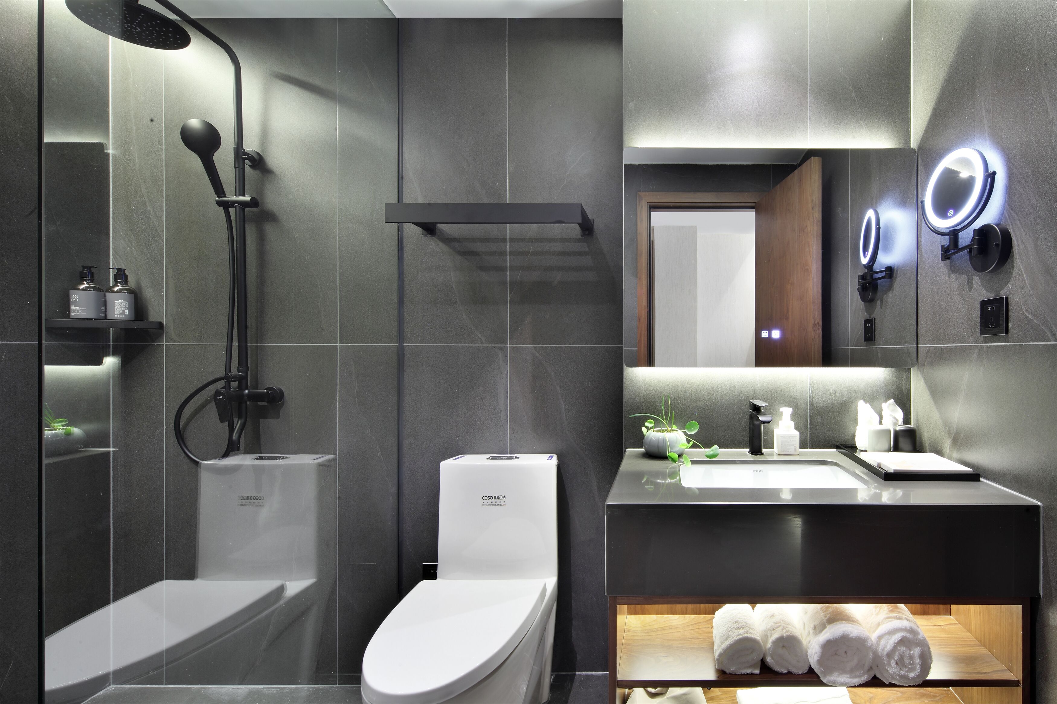 A modern bathroom with a shower, toilet, and sink.