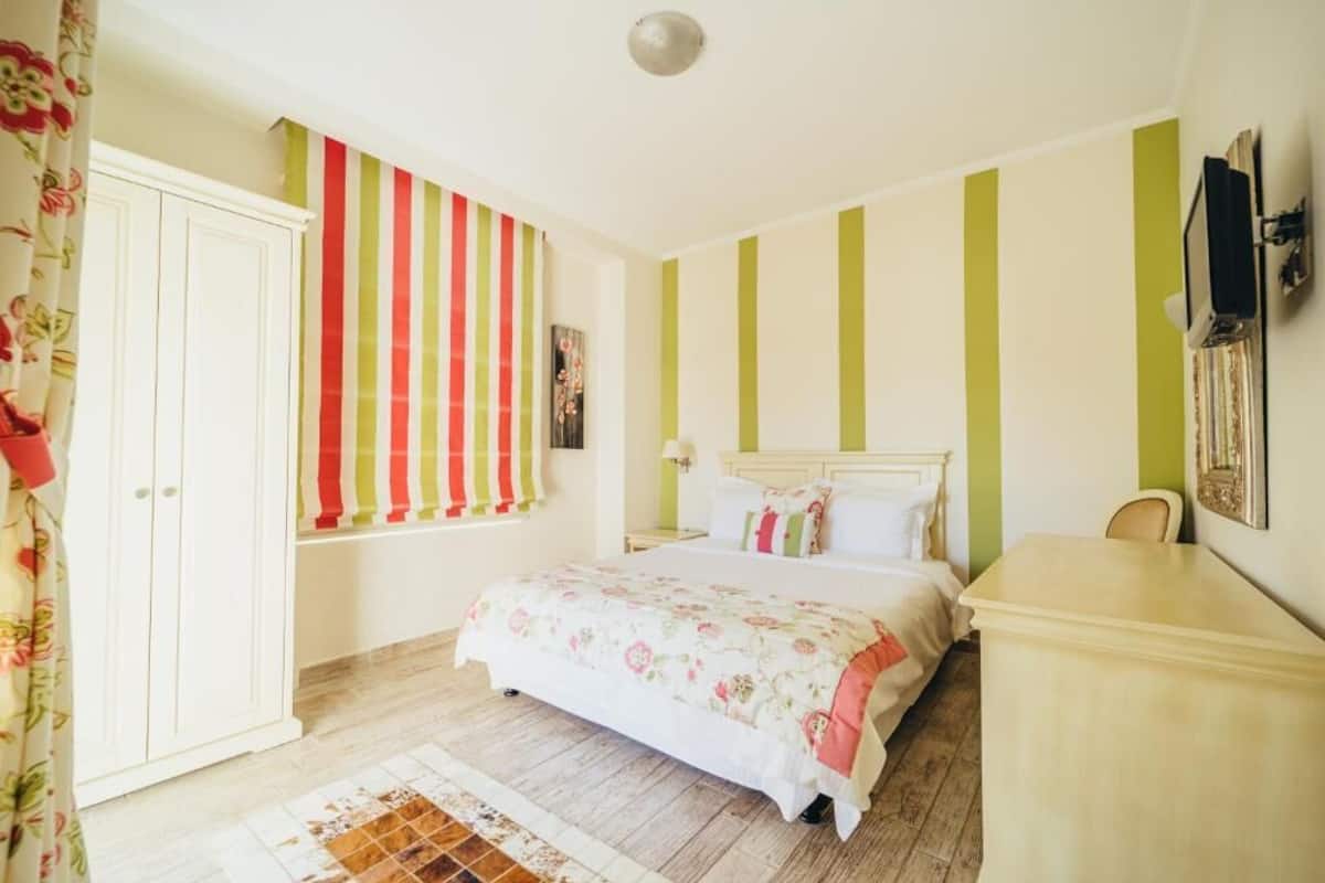 Une chambre à coucher avec un lit, une armoire, un bureau et un téléviseur.