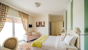 Une chambre d’hôtel comprenant un lit, un bureau, une chaise, un canapé et une armoire.